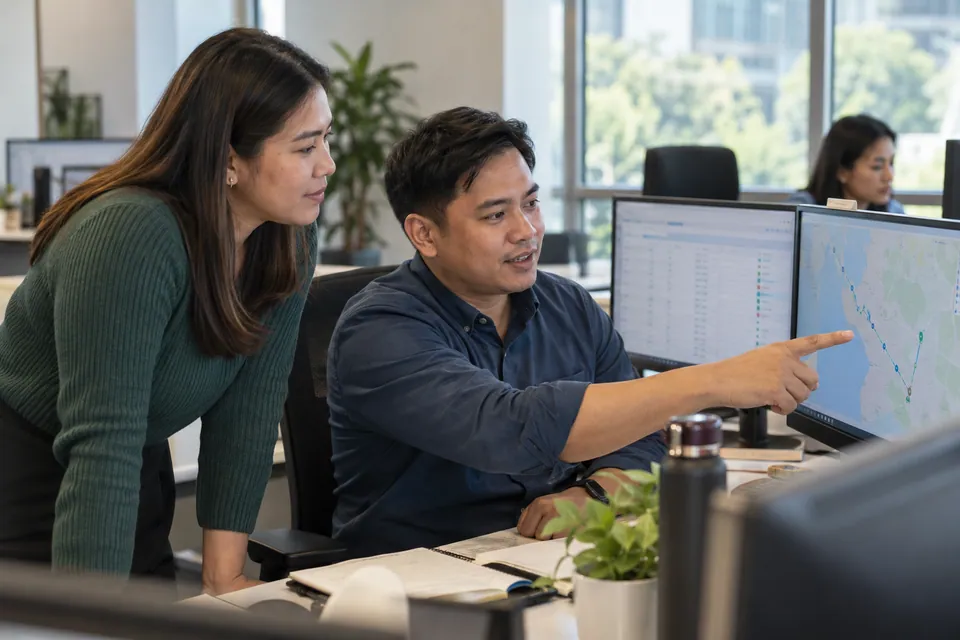 Logistics colleagues reviewing route information in an office